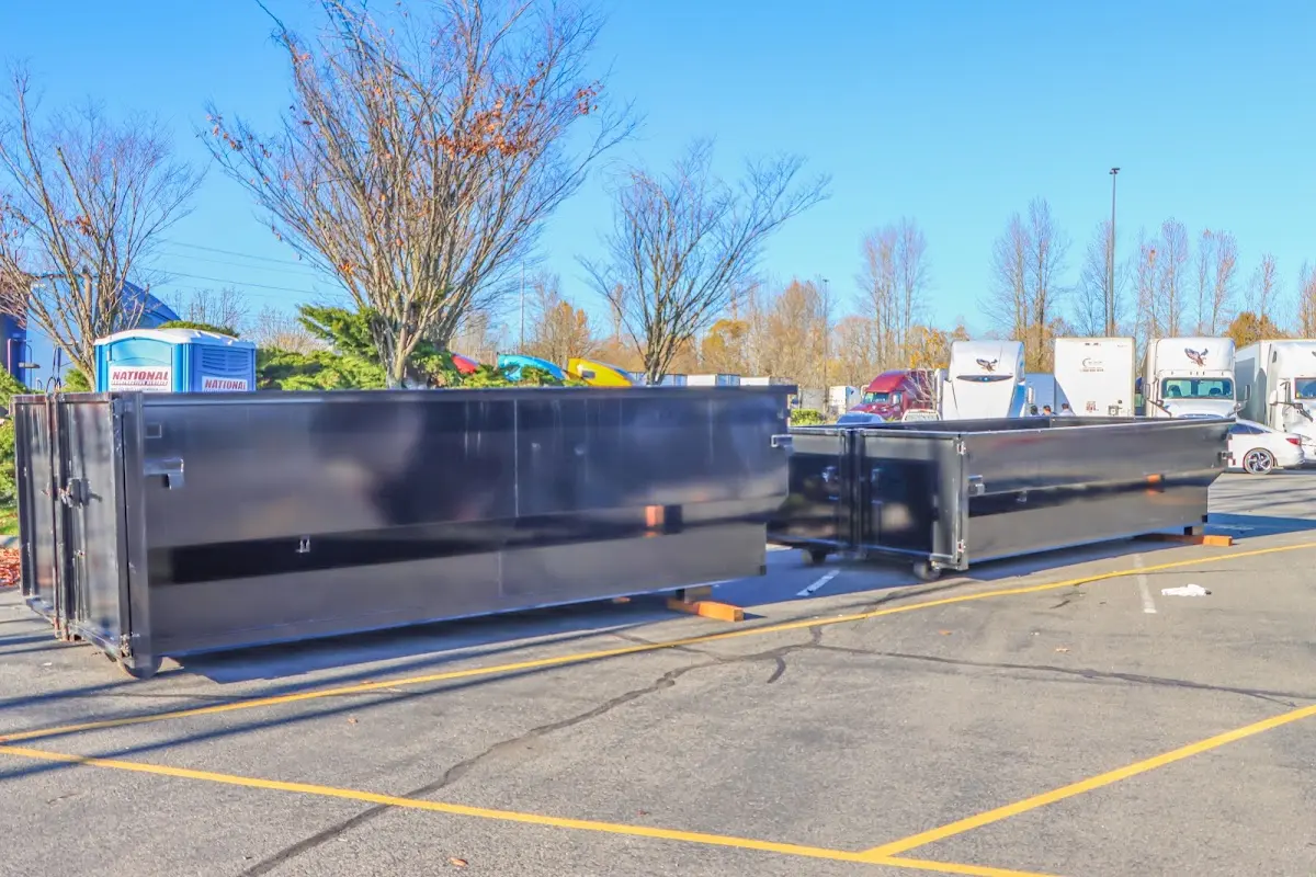 Professional dumpster rental service with roll-off container on residential driveway in Ashland